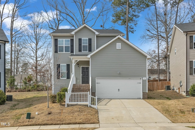 traditional home with concrete driveway, fence, and central AC unit