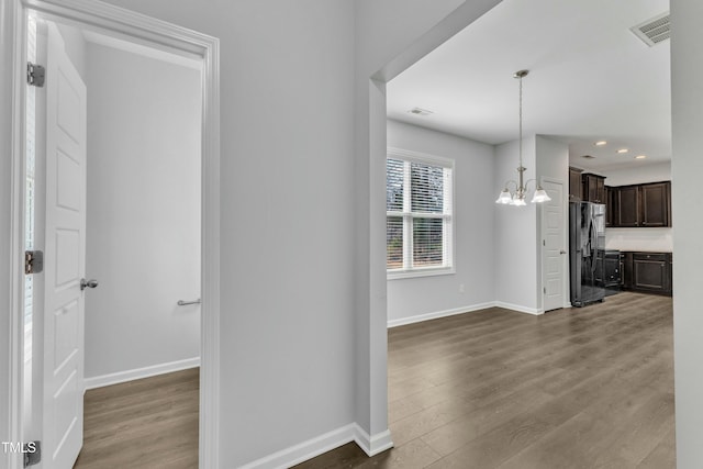 interior space featuring a chandelier, recessed lighting, visible vents, baseboards, and dark wood finished floors