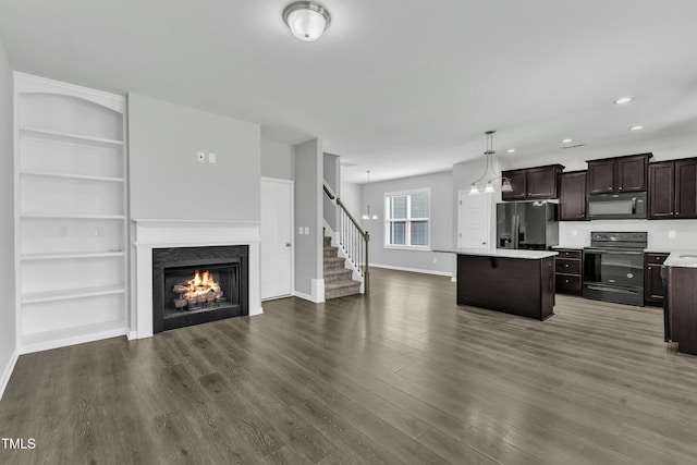 kitchen with a kitchen island, open floor plan, light countertops, dark brown cabinets, and black appliances