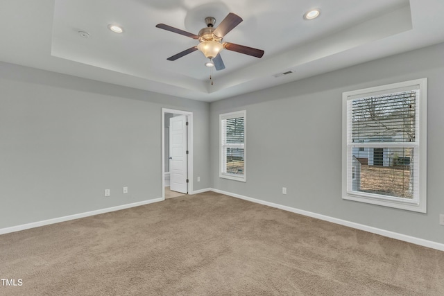 unfurnished room featuring recessed lighting, a raised ceiling, visible vents, carpet flooring, and baseboards