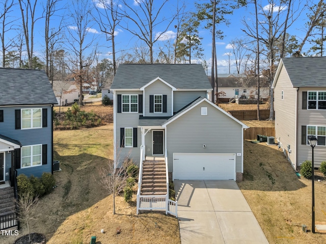 traditional-style home featuring central AC unit, stairway, a front lawn, and concrete driveway