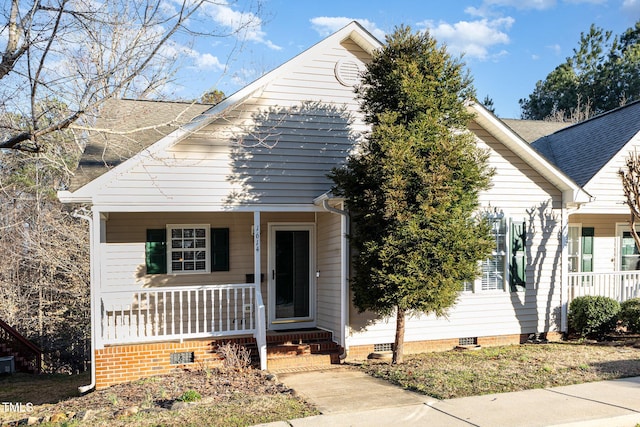 view of front facade featuring crawl space, roof with shingles, and covered porch