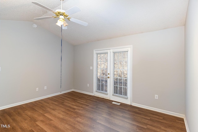 spare room featuring dark wood-style floors, visible vents, vaulted ceiling, ceiling fan, and baseboards