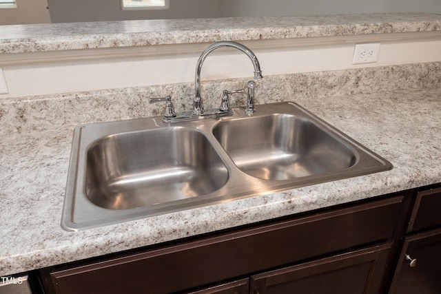 interior details with light countertops, a sink, and dark brown cabinetry