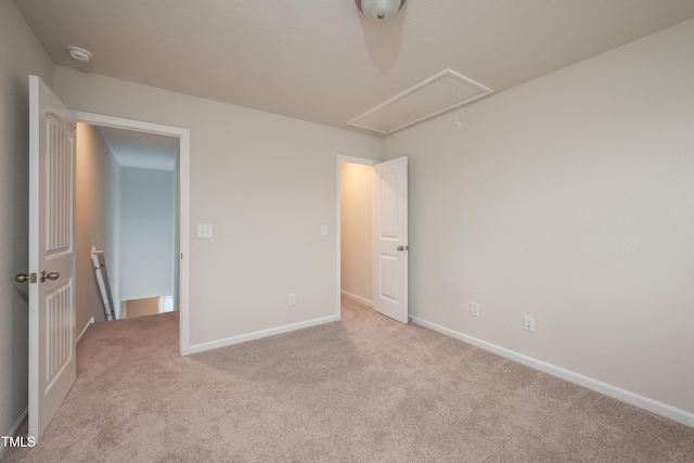 unfurnished bedroom featuring attic access, carpet floors, and baseboards