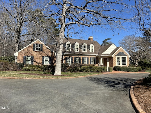 view of front of house featuring brick siding and a chimney