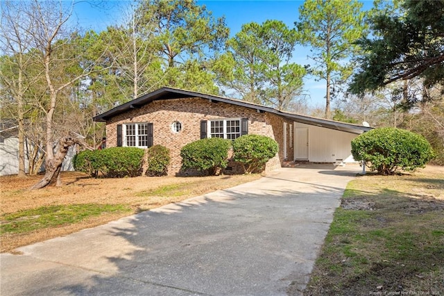 view of front of home with a carport, concrete driveway, and brick siding