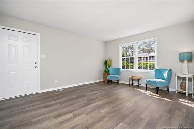 living area with baseboards and wood finished floors