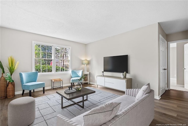 living area with a textured ceiling, wood finished floors, and baseboards