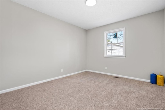 carpeted empty room featuring visible vents and baseboards