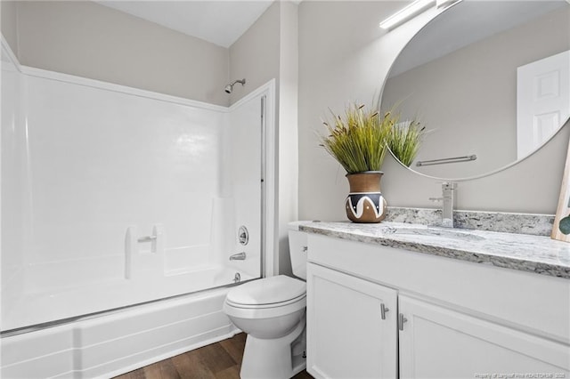 bathroom with toilet, shower / washtub combination, wood finished floors, and vanity