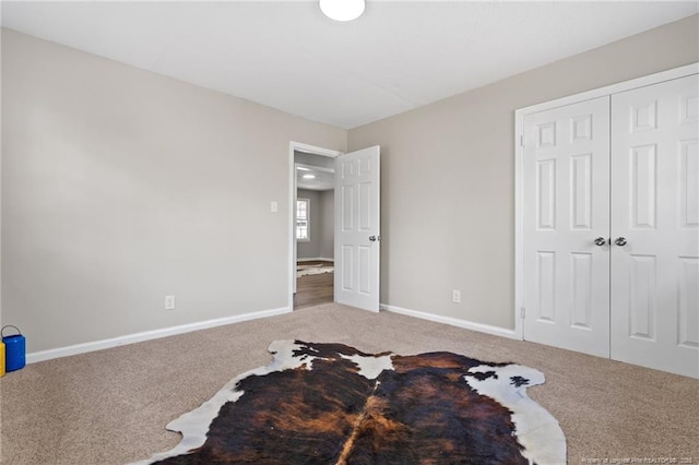 bedroom with a closet, carpet, and baseboards