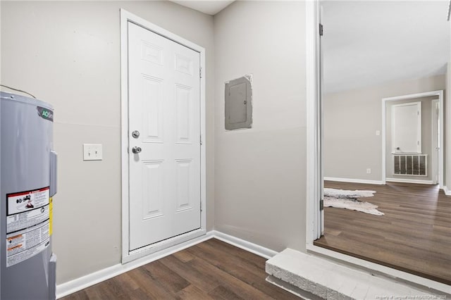 entrance foyer with water heater, visible vents, baseboards, and wood finished floors