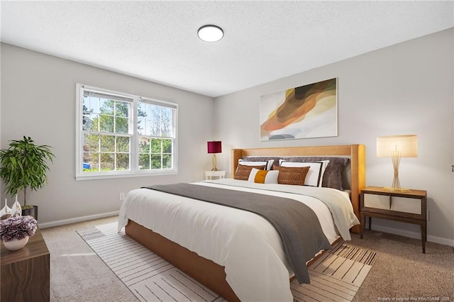 carpeted bedroom with a textured ceiling and baseboards