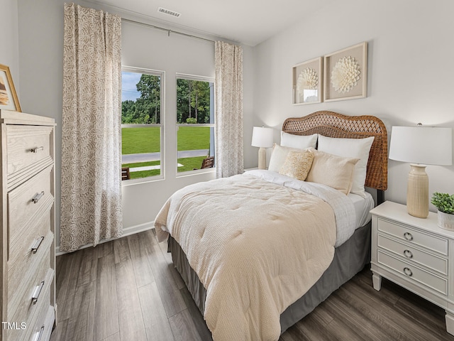 bedroom with baseboards, visible vents, and dark wood-type flooring