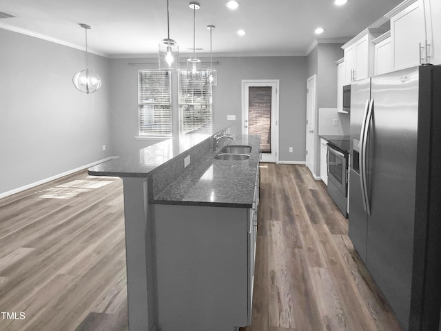 kitchen featuring hanging light fixtures, a center island with sink, appliances with stainless steel finishes, and white cabinets