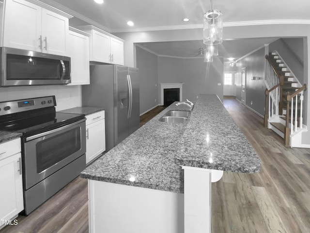 kitchen with an island with sink, white cabinetry, appliances with stainless steel finishes, and a sink