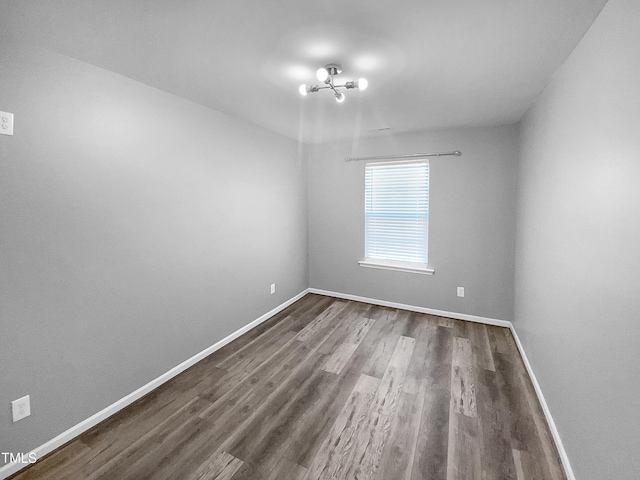 spare room featuring baseboards and wood finished floors