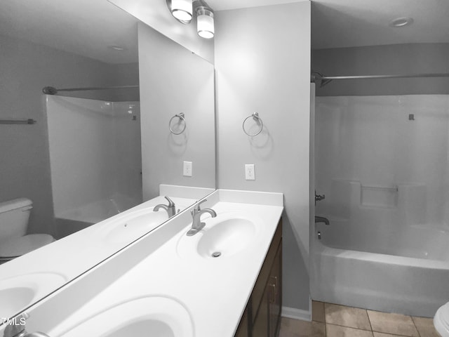 bathroom with double vanity, toilet,  shower combination, tile patterned flooring, and a sink