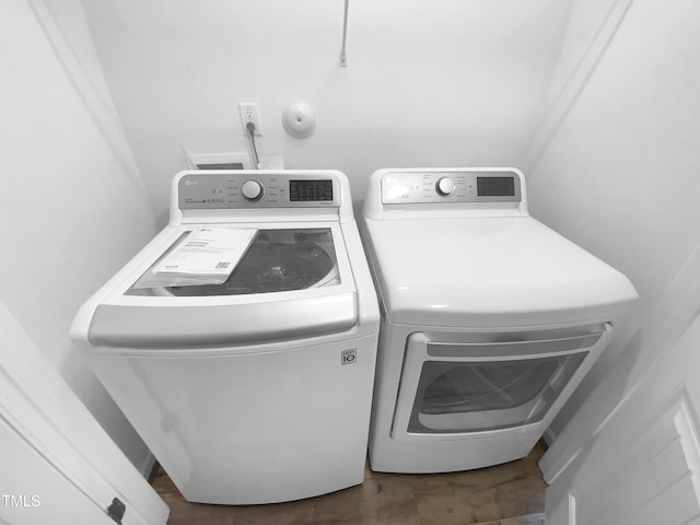 laundry area featuring dark wood-style floors, laundry area, and washer and clothes dryer