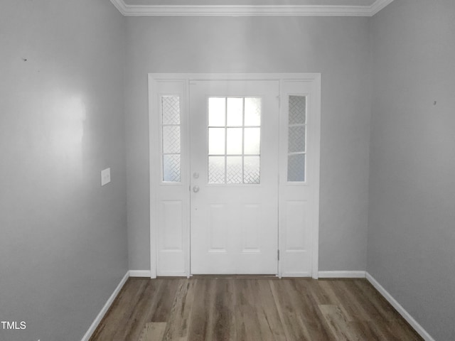 foyer with baseboards, ornamental molding, and wood finished floors