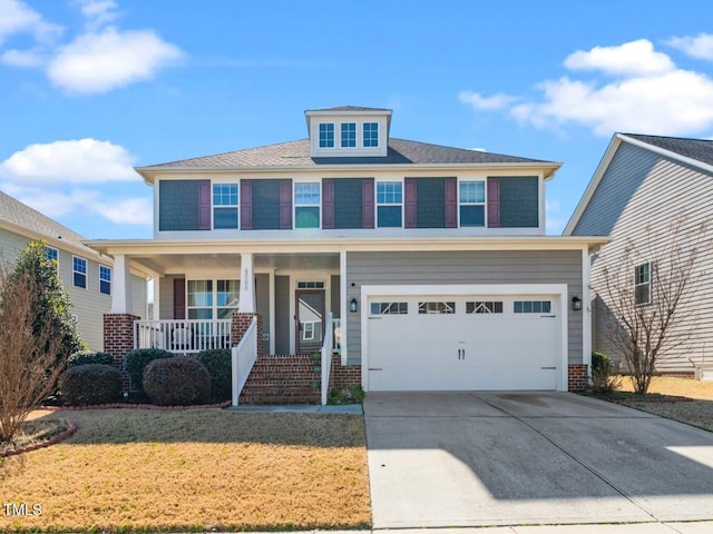 american foursquare style home with a garage, concrete driveway, a porch, and a front lawn