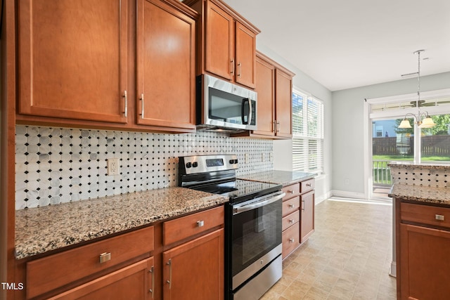 4508 Brintons Cottage St, Raleigh, NC 27616 - kitchen with appliances with stainless steel finishes, decorative backsplash, light stone counters, baseboards, and brown cabinetry