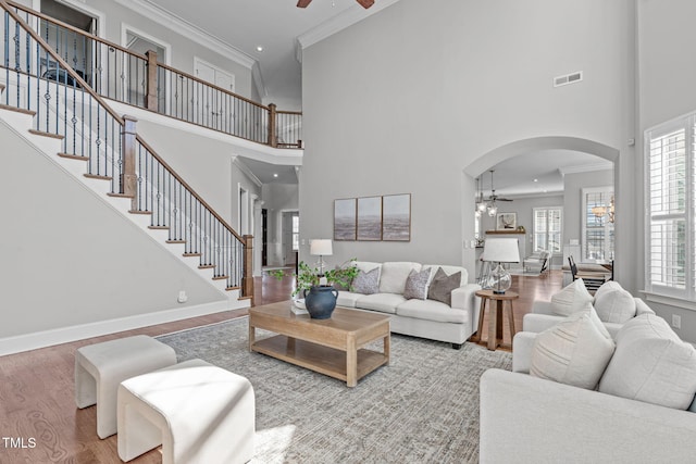 living room featuring ornamental molding, stairway, and wood finished floors