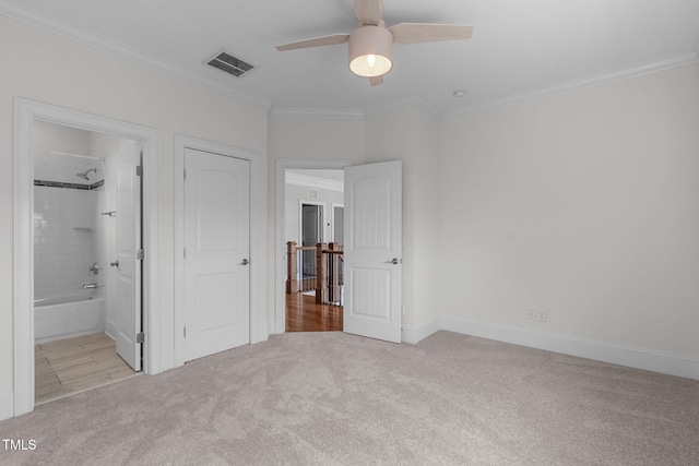 unfurnished bedroom featuring ceiling fan, carpet floors, visible vents, baseboards, and ornamental molding