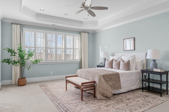 carpeted bedroom featuring baseboards, a raised ceiling, and crown molding