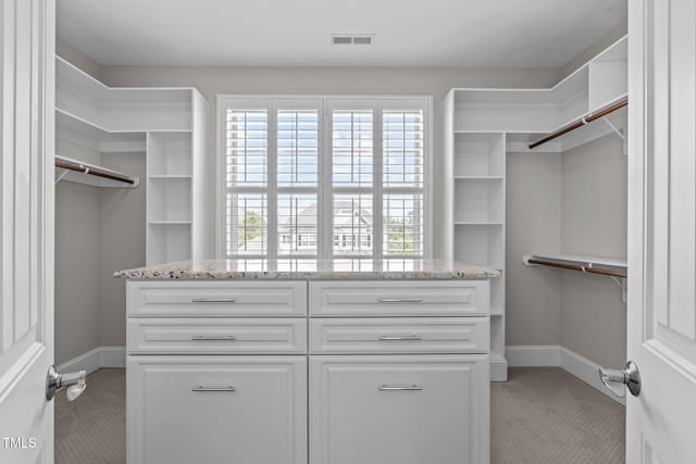 walk in closet with visible vents and light carpet