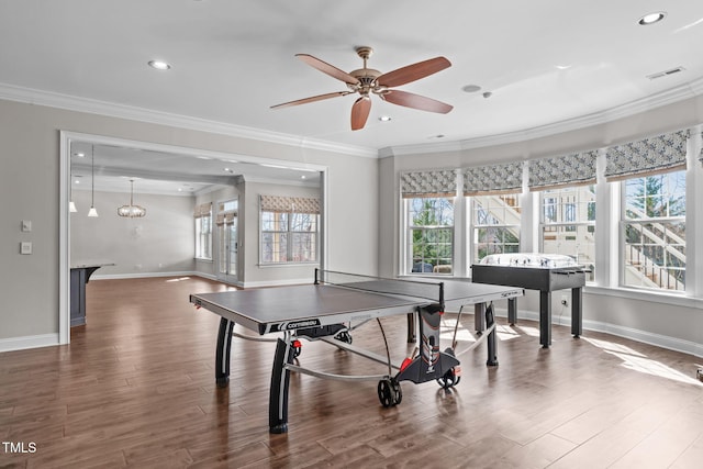 recreation room with baseboards, ornamental molding, wood finished floors, and recessed lighting