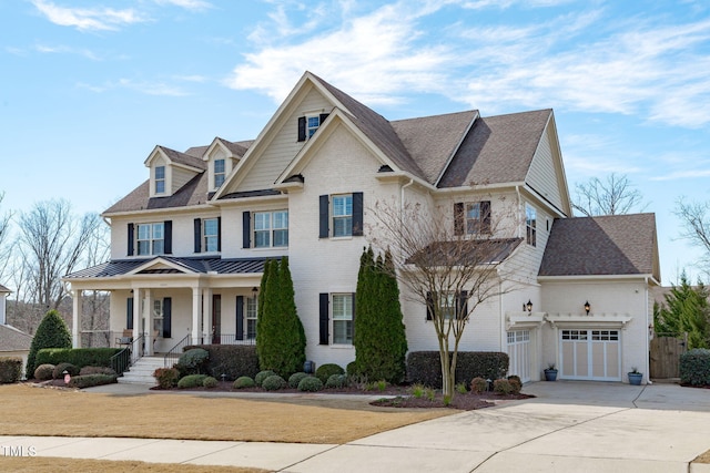 view of front of property with brick siding, covered porch, concrete driveway, a standing seam roof, and a garage