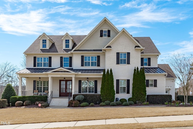 craftsman-style house with metal roof, brick siding, a standing seam roof, and a porch