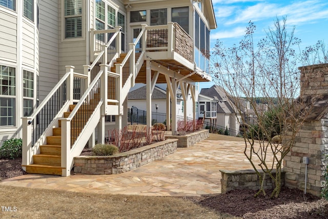 back of property featuring fence, stairway, and a patio