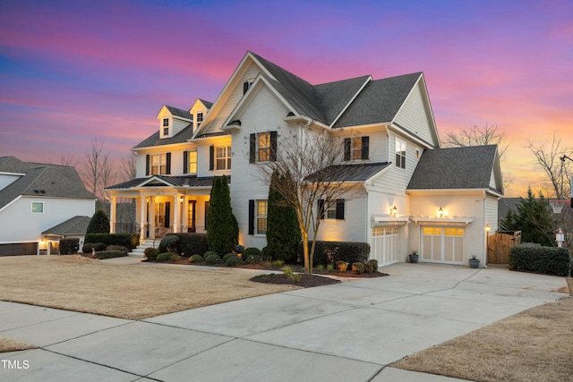 view of front facade featuring concrete driveway, an attached garage, a standing seam roof, metal roof, and fence