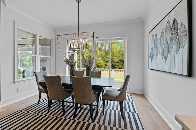 dining space with light wood finished floors, baseboards, a wealth of natural light, and an inviting chandelier