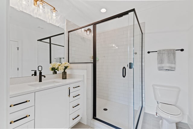 bathroom featuring toilet, a stall shower, and vanity