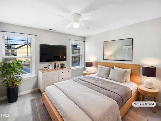 carpeted bedroom with baseboards, visible vents, and a ceiling fan