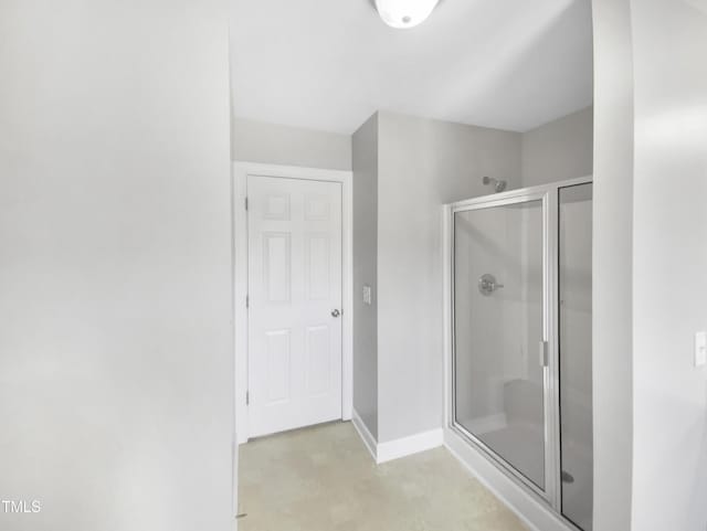 bathroom featuring a stall shower and baseboards