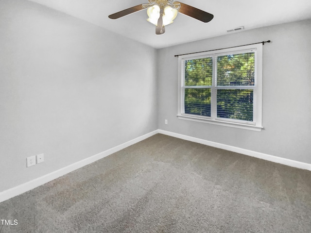 carpeted spare room with a ceiling fan, visible vents, and baseboards