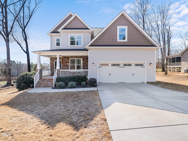 craftsman-style house with driveway, covered porch, and stone siding