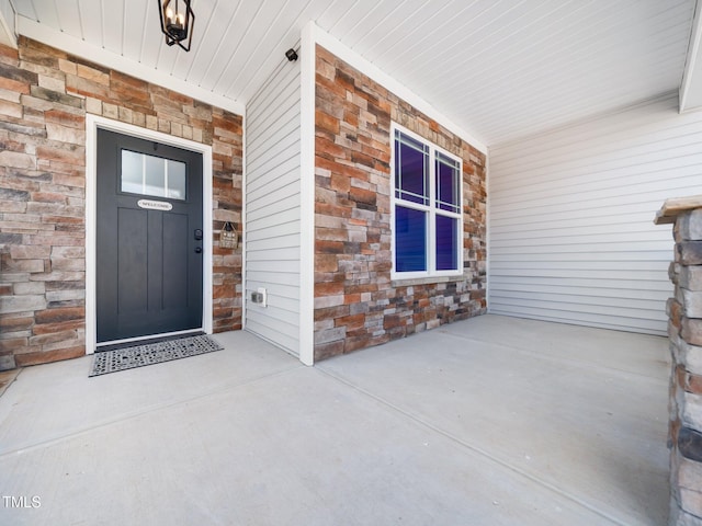 property entrance with stone siding and covered porch