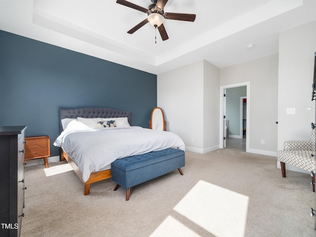 carpeted bedroom featuring a raised ceiling, ceiling fan, and baseboards