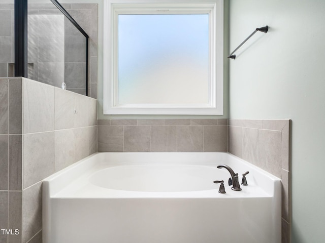 full bathroom featuring a tile shower and a bath