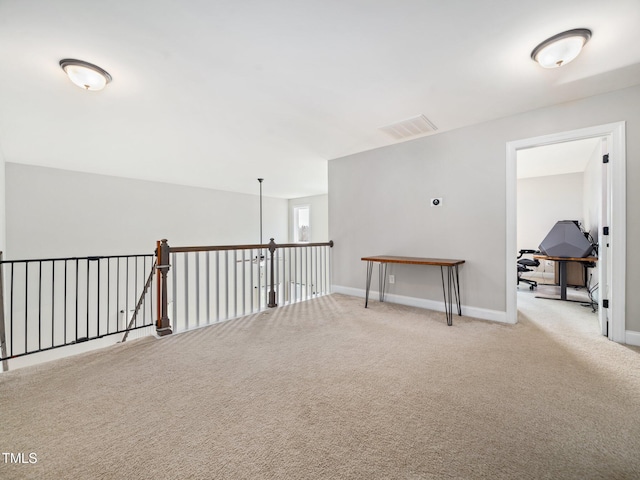 empty room with baseboards, visible vents, and light colored carpet