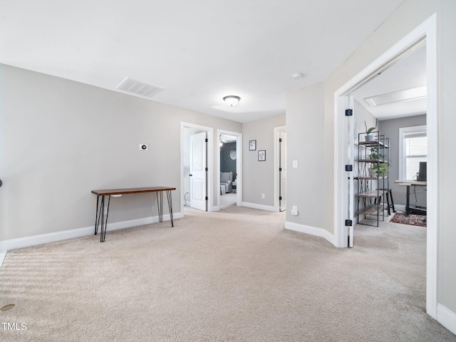 spare room with light colored carpet, visible vents, and baseboards