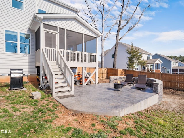 back of property with a sunroom, a fenced backyard, a patio area, and stairs