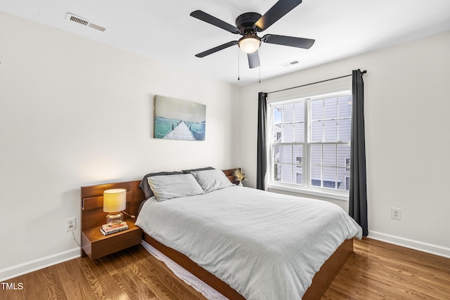 bedroom with visible vents, baseboards, and wood finished floors