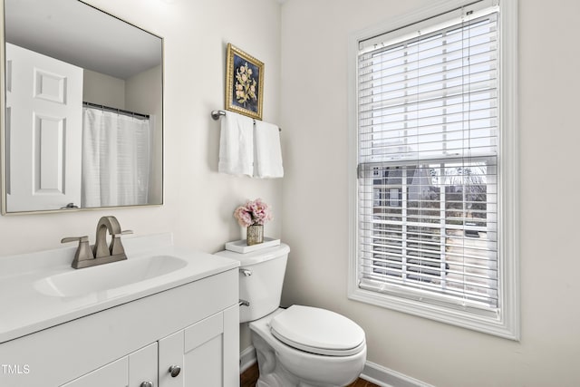 full bath with toilet, baseboards, and vanity